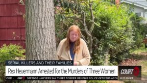 A woman stands next to a tree