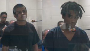 split screen showing two teenagers in jail clothing behind plexiglass