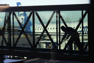 A worker cleans a jet bridge.