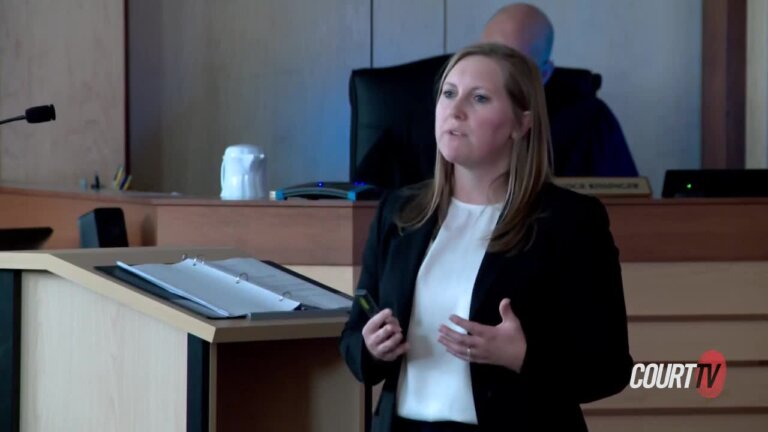 A woman in a suit speaks in court
