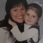 A smiling woman and little girl hug each other