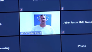 A man appears on a video call on a monitor