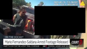 bodycamera video shows a handcuffed man sitting in the bed of a pickup truck.