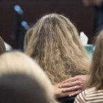 people embrace in the gallery of a courtroom