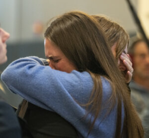 Caitlin Cash hugs a woman outside of court