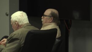 A man sits in court with his attorney