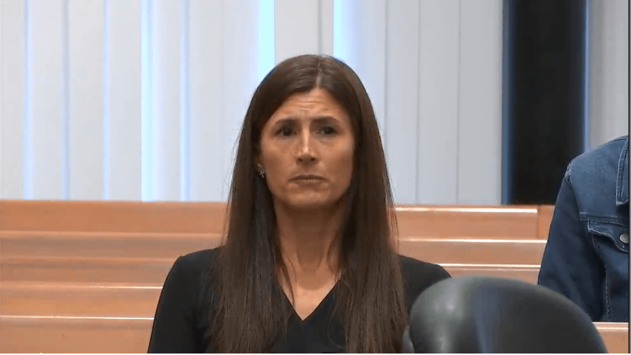 A woman sits in court