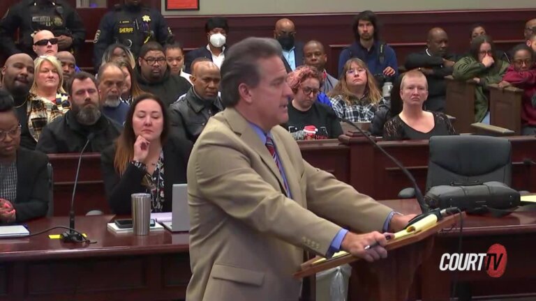 A man in a suit speaks at a lectern