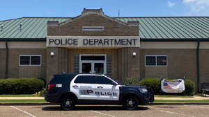 a police cruiser is parked outside of a building that says 'police department'