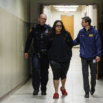 Christopher Preciado, center, is escorted by San Antonio Police