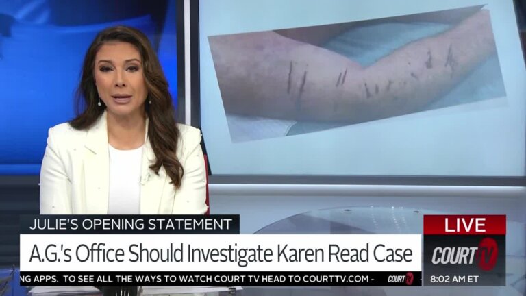 Julie Grant speaks to the camera with a picture of an arm with cuts in a monitor behind her