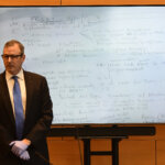 man stands in front of whiteboard