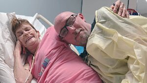 paula belmonte and franklin tucker pose in hospital bed