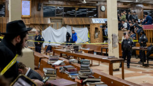 Hasidic Jewish students observe as law enforcement establishes a perimeter