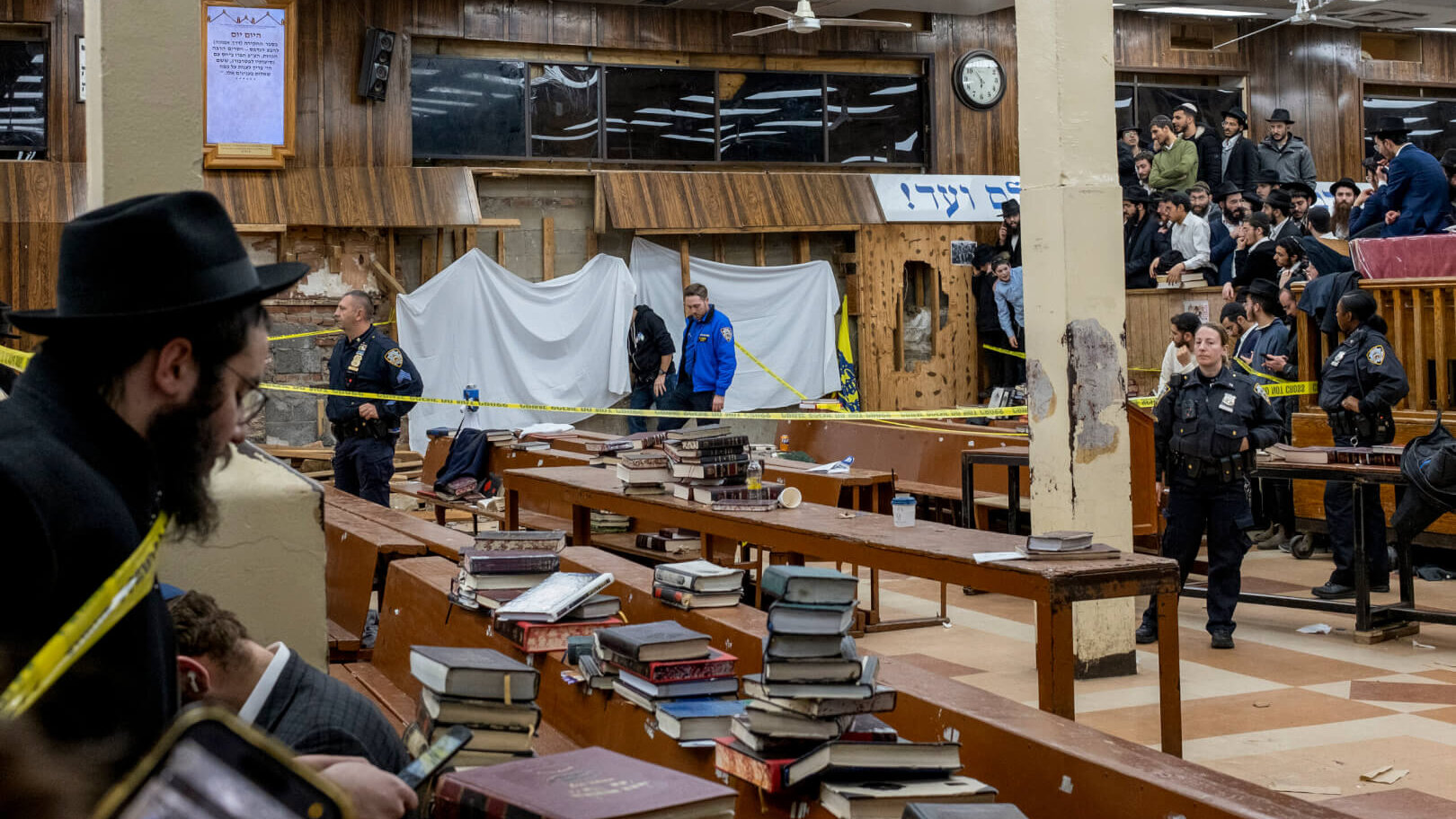 Hasidic Jewish students observe as law enforcement establishes a perimeter