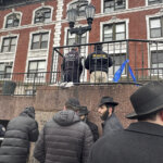 Hasidic Jewish students observe as law enforcement establishes a perimeter