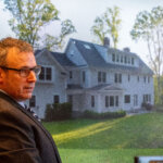 Witness testifies with photo of house in background