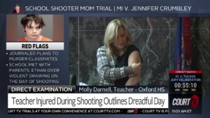 Oxford teacher shows jury her bullet scar.