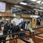 Hasidic Jewish students observe as law enforcement establishes a perimeter