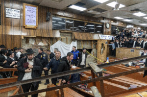 Hasidic Jewish students observe as law enforcement establishes a perimeter