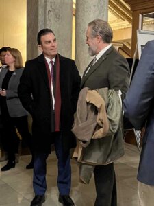 Two men stand in a courthouse