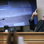 man testifies in front of a photo