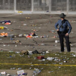 A police officer looks over a scene littered with trash