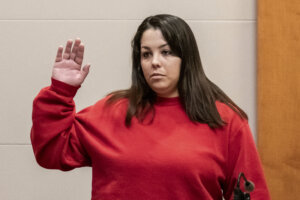 Kayla Montgomery stands with her arm raised as she is sworn in