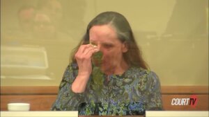 Annette Harvey dabs her eye with a tissue.