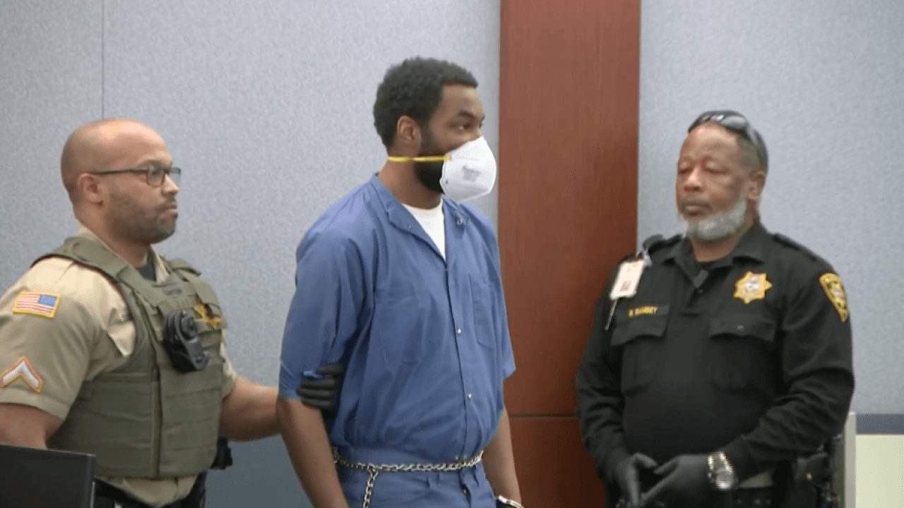 Deobra Redden wears a mask and shackles in court