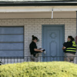 Police stand outside of a door