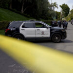 Police tape blocks a street i