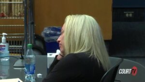 A blonde woman sits in court