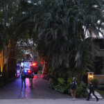 Federal agents walk at the entrance to a property