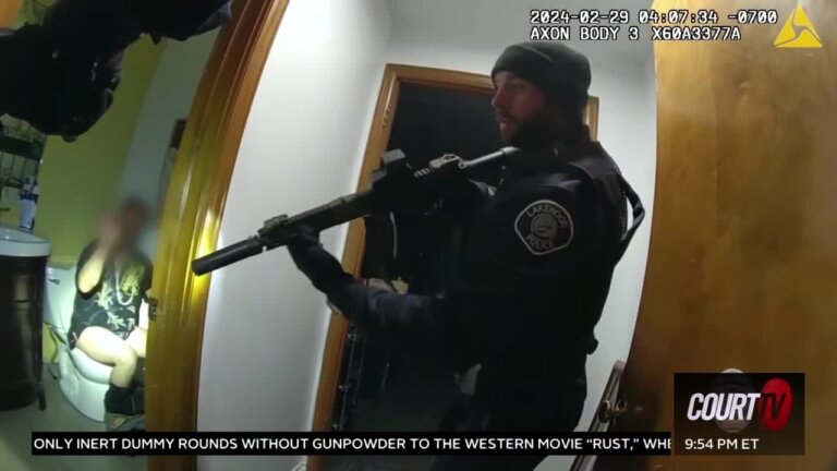 Body cam still of cops busting home invasion suspect on toilet.