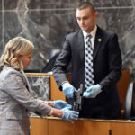 witness and prosecutor display gun to jury