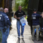 A law enforcement agent carries a bag