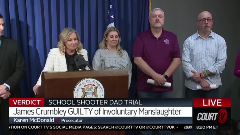 Prosecutor and victims families stand behind a podium