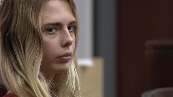 woman stares as camera in court