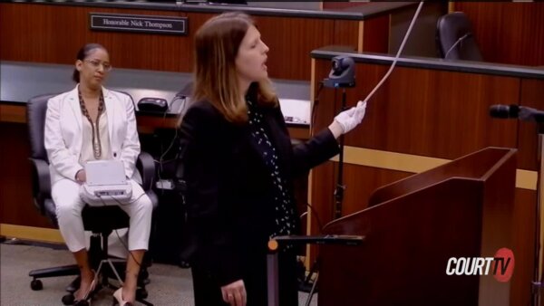 Prosecutor Sara Miller holds up a curtain rod for the jury