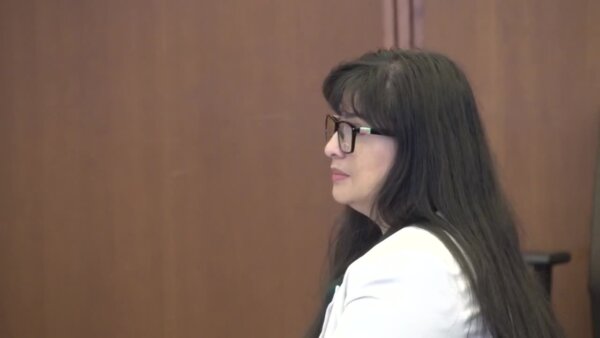 woman sits in court