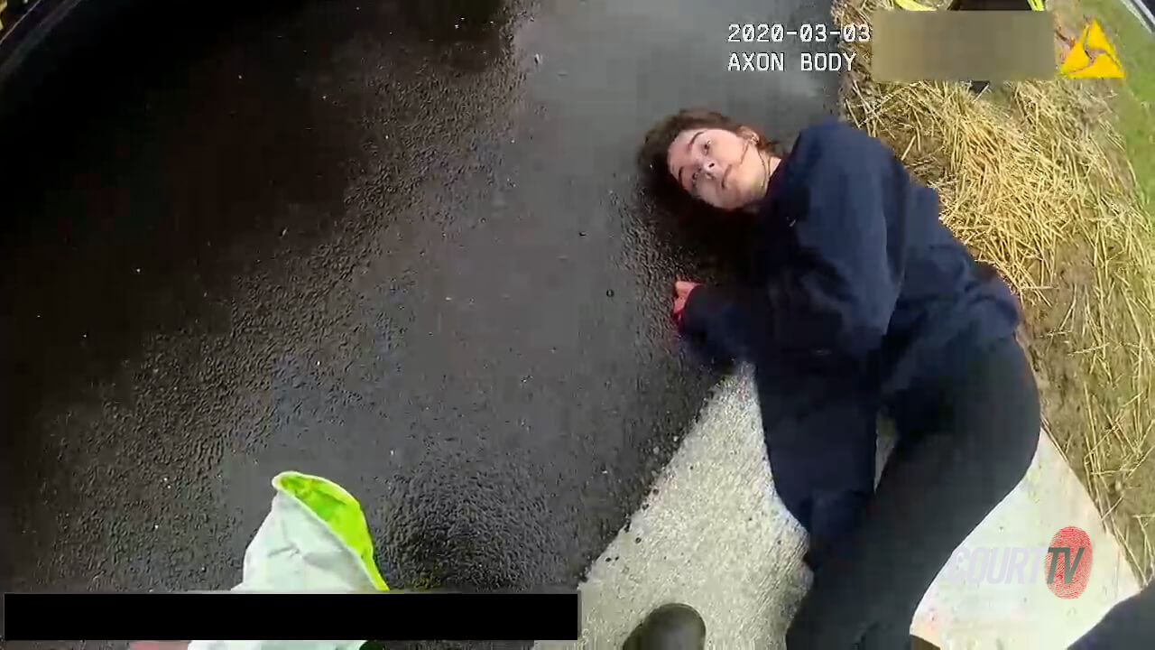 Brunette woman lays on the ground in shock