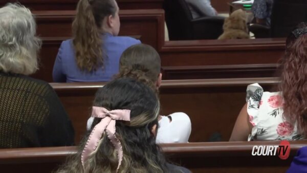 back of heads of people sitting in courtroom gallery