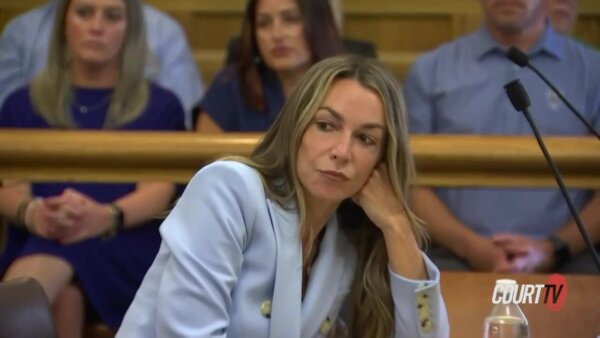 Karen Read props her cheek on her fist in court