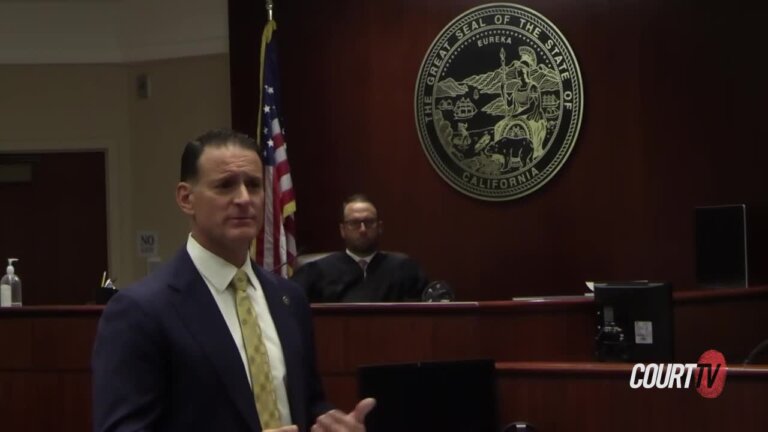 Sharp-dressed attorney delivers an argument. Judge is on the bench in the background.