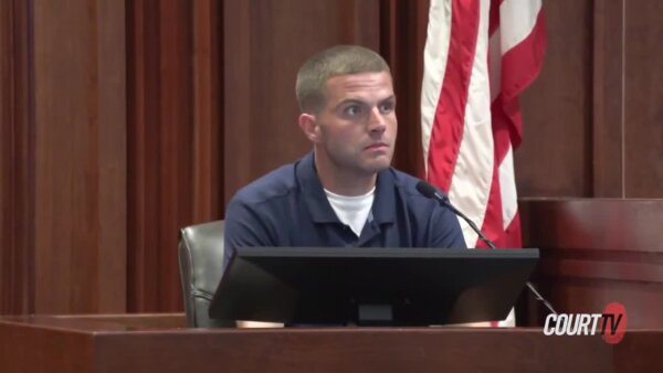 Young, blonde male witness on the stand wears a navy blue polo shirt