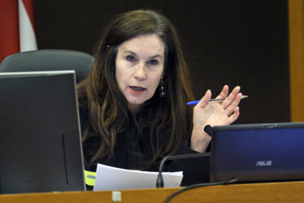 A judge holds her hand up