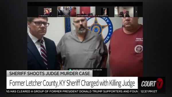 Sheriff Shawn Stines stands between two men on camera