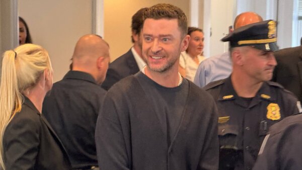 Pop singer smiling in court wearing pearl necklace