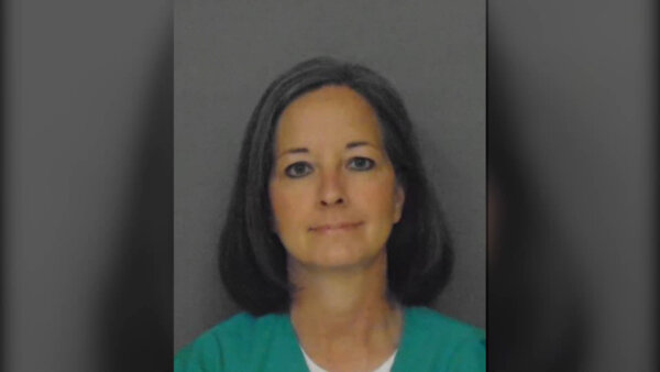 Female mug shot; woman wears green prison garb